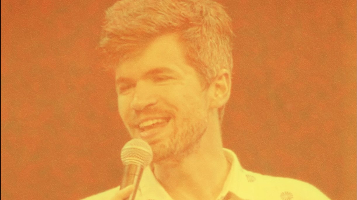 Ivo Graham smiling at the mic, from the Live from the Bloomsbury Theatre artwork