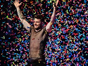 Performer celebrating on stage as confetti falls