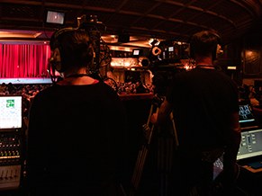 Camera operators and the gallery at the back of a packed theatre